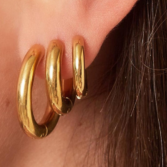 Massive mittelgroße Edelstahl Creolen in Gold.