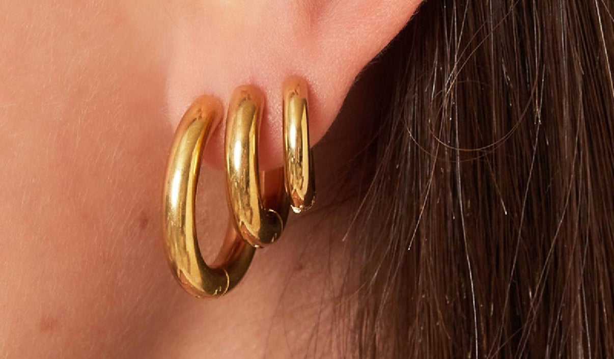 Massive mittelgroße Edelstahl Creolen in Gold.