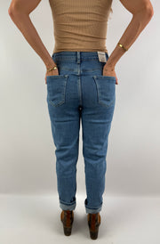 Rückenansicht einer figurbetonten High-Waist-Jeans in hellblauem Denim, kombiniert mit einem beigefarbenen Top – lässig und zeitlos.