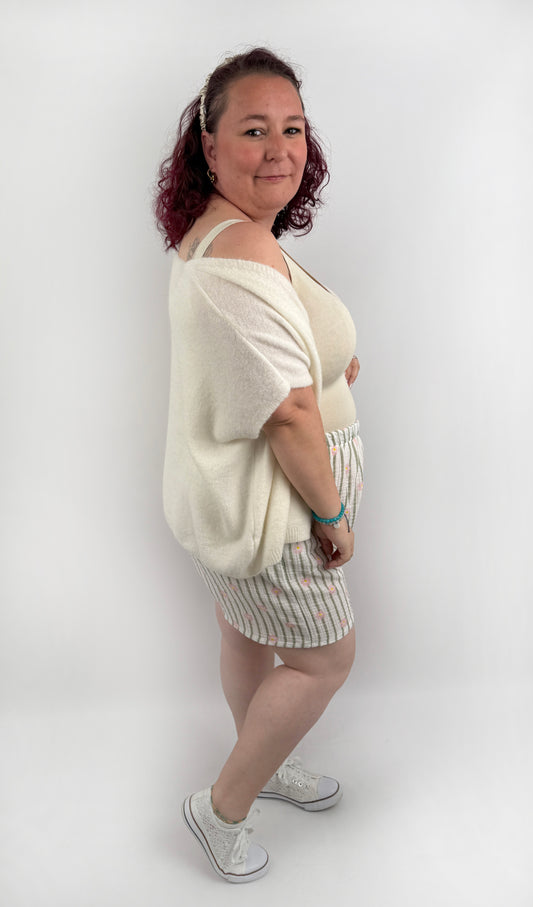 Kurze weiße Musselin Shorts mit olive farbenen Streifen und rosa Blümchen.