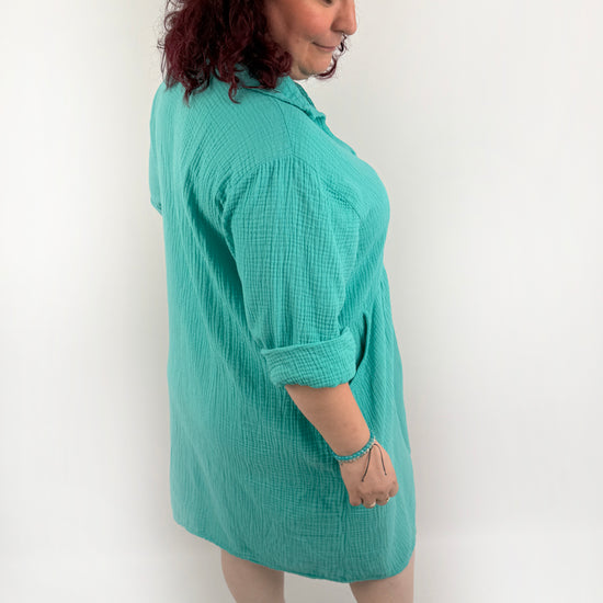 XL Musselin Kleid mit Knopfreiehe und seitlichen Taschen und 3/4 Ärmeln in der Farbe Türkis.