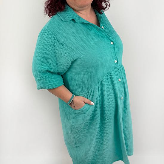 XL Musselin Kleid mit Knopfreiehe und seitlichen Taschen und 3/4 Ärmeln in der Farbe Türkis.