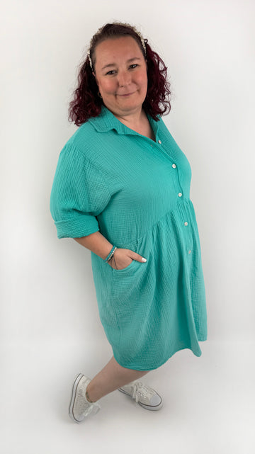 XL Musselin Kleid mit Knopfreiehe und seitlichen Taschen und 3/4 Ärmeln in der Farbe Türkis.