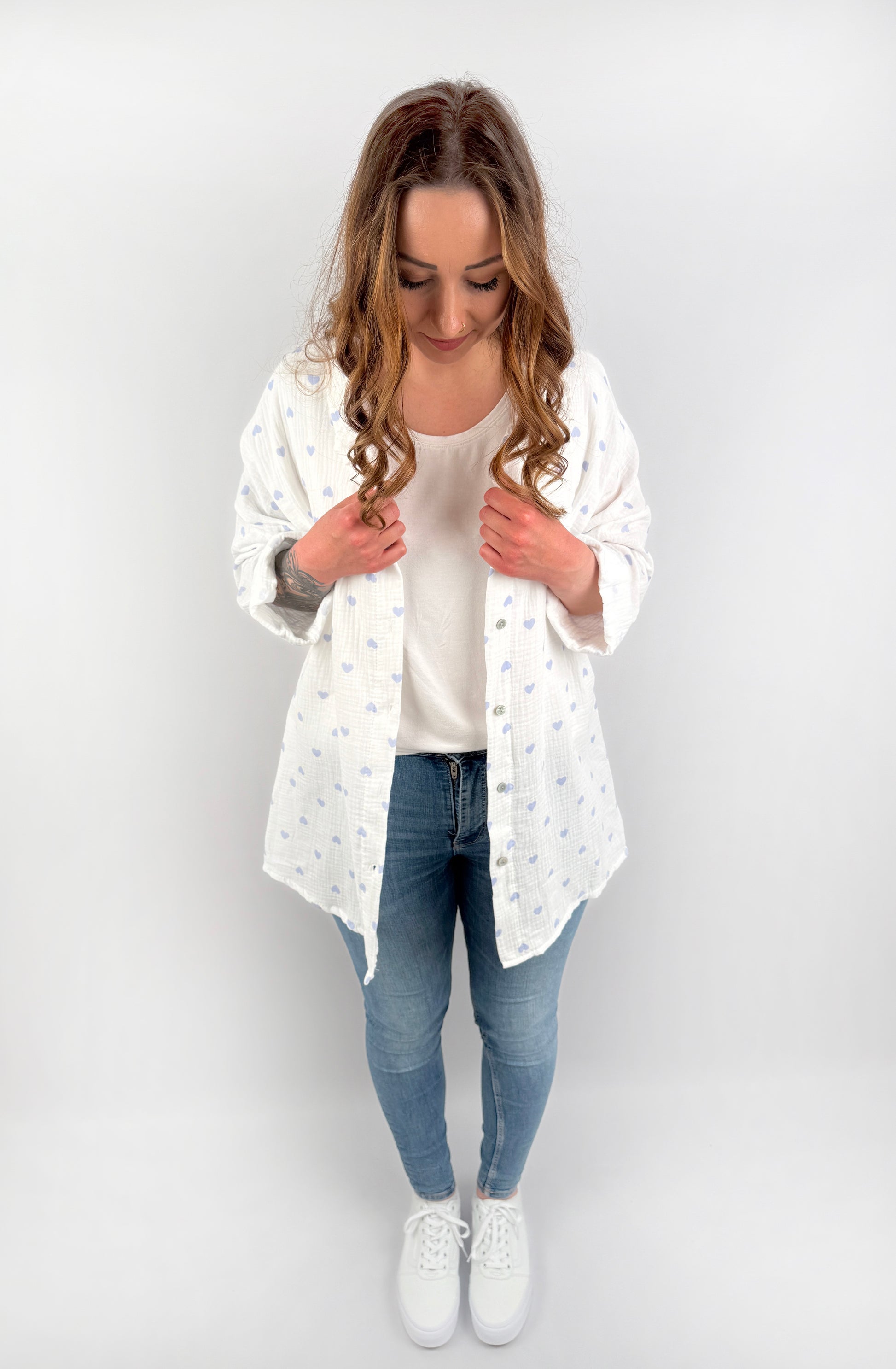 Langärmelige MusselinBluse in weiß mit Pastell farbenen Herzen.