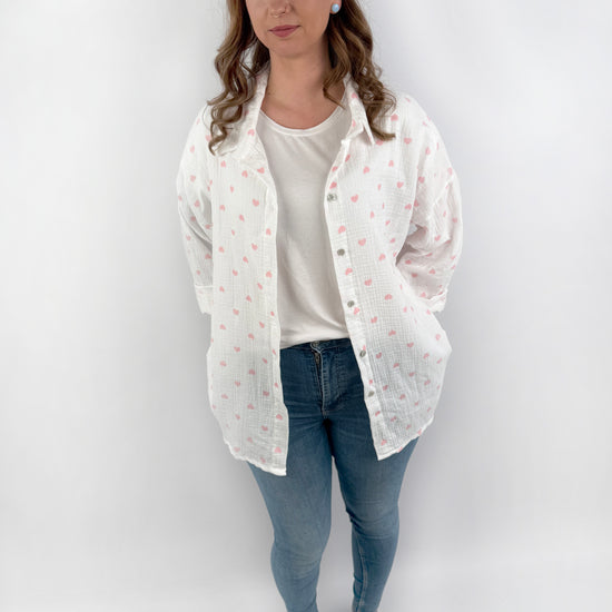 Langärmelige MusselinBluse in weiß mit Pastell farbenen Herzen.