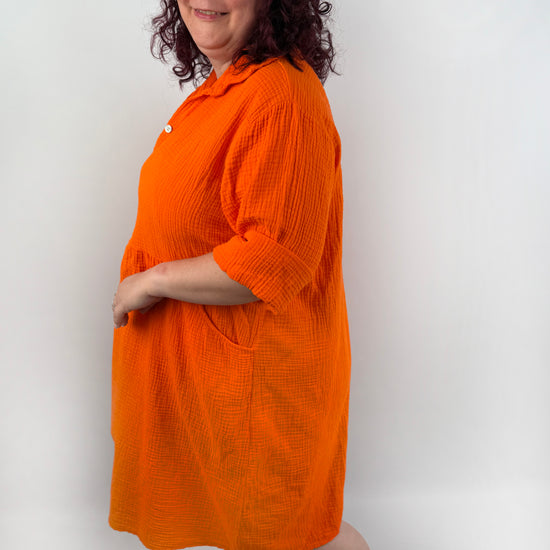 XL Musselin Kleid mit Knopfreiehe und seitlichen Taschen und 3/4 Ärmeln in der Farbe Orange.