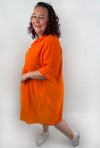 XL Musselin Kleid mit Knopfreiehe und seitlichen Taschen und 3/4 Ärmeln in der Farbe Orange.