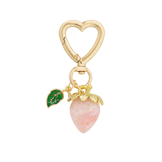 Rosa farbener Schlüsselanhänger in Erdbeerfom mit grünem Blatt und herzförmigen goldenen Karabiner.