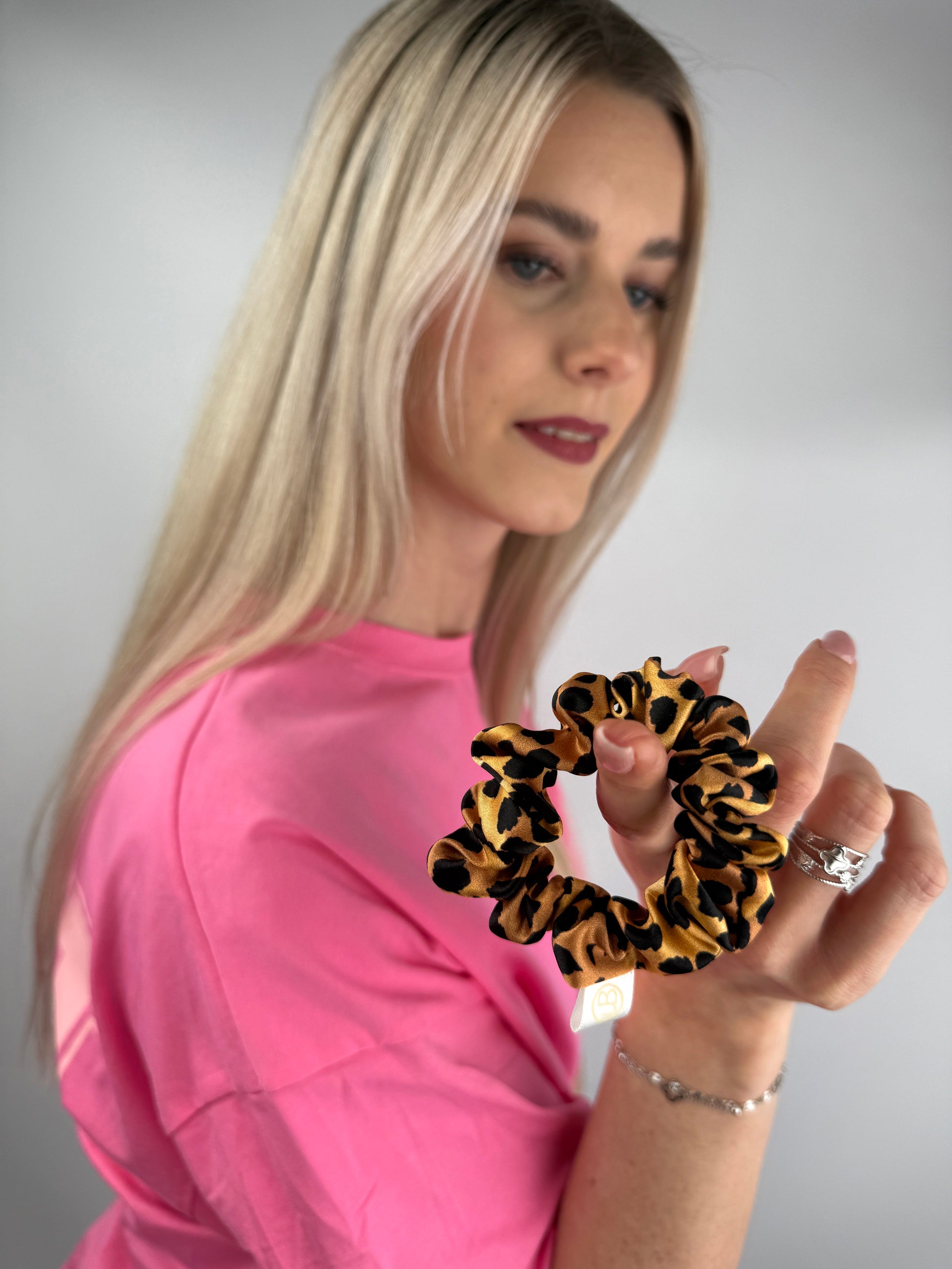 Nahaufnahme eines Seiden-Scrunchies mit Leopardmuster.