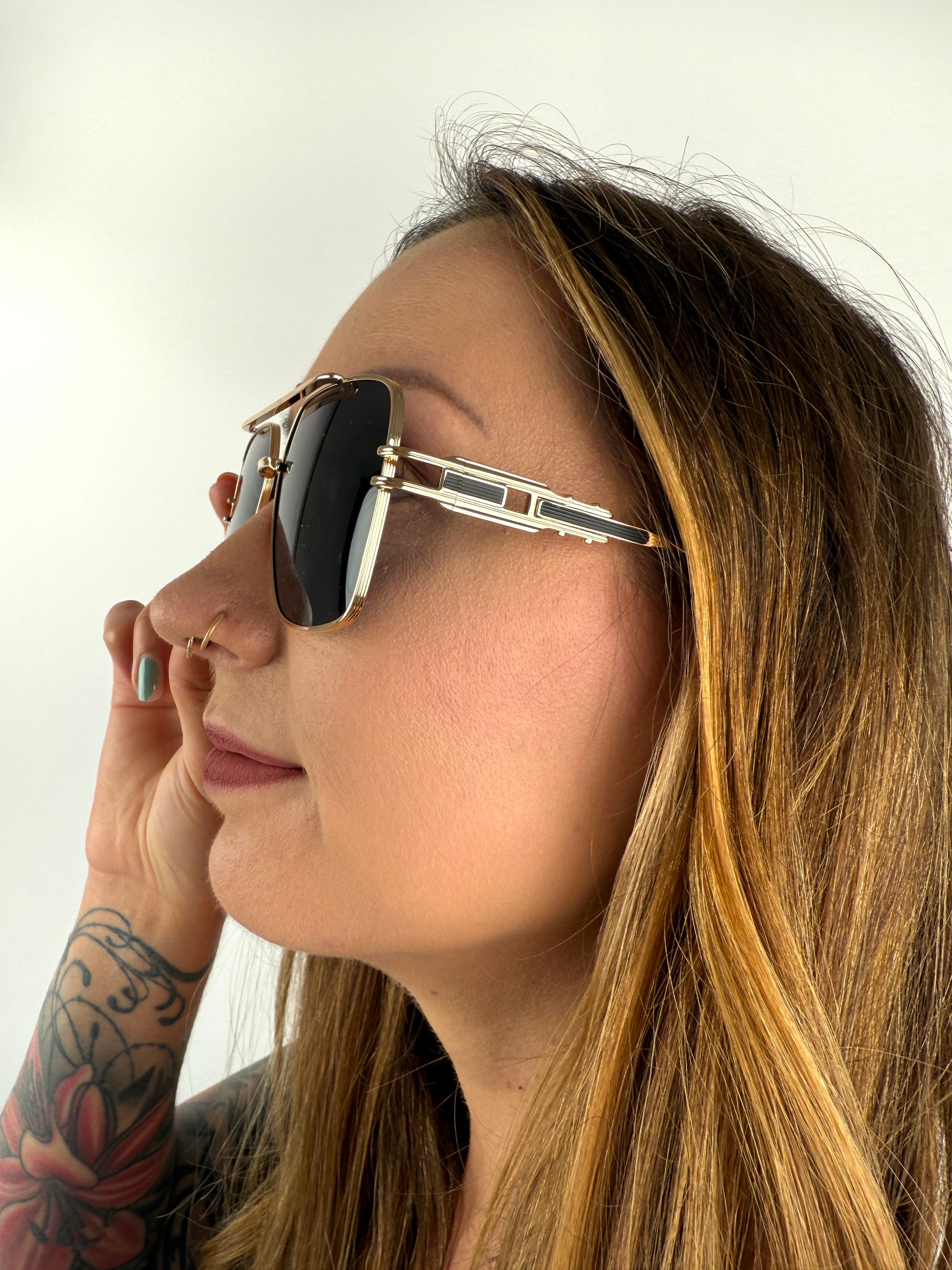 Sonnenbrille mit feinem goldenem GEstell und schwarzen Gläsern.