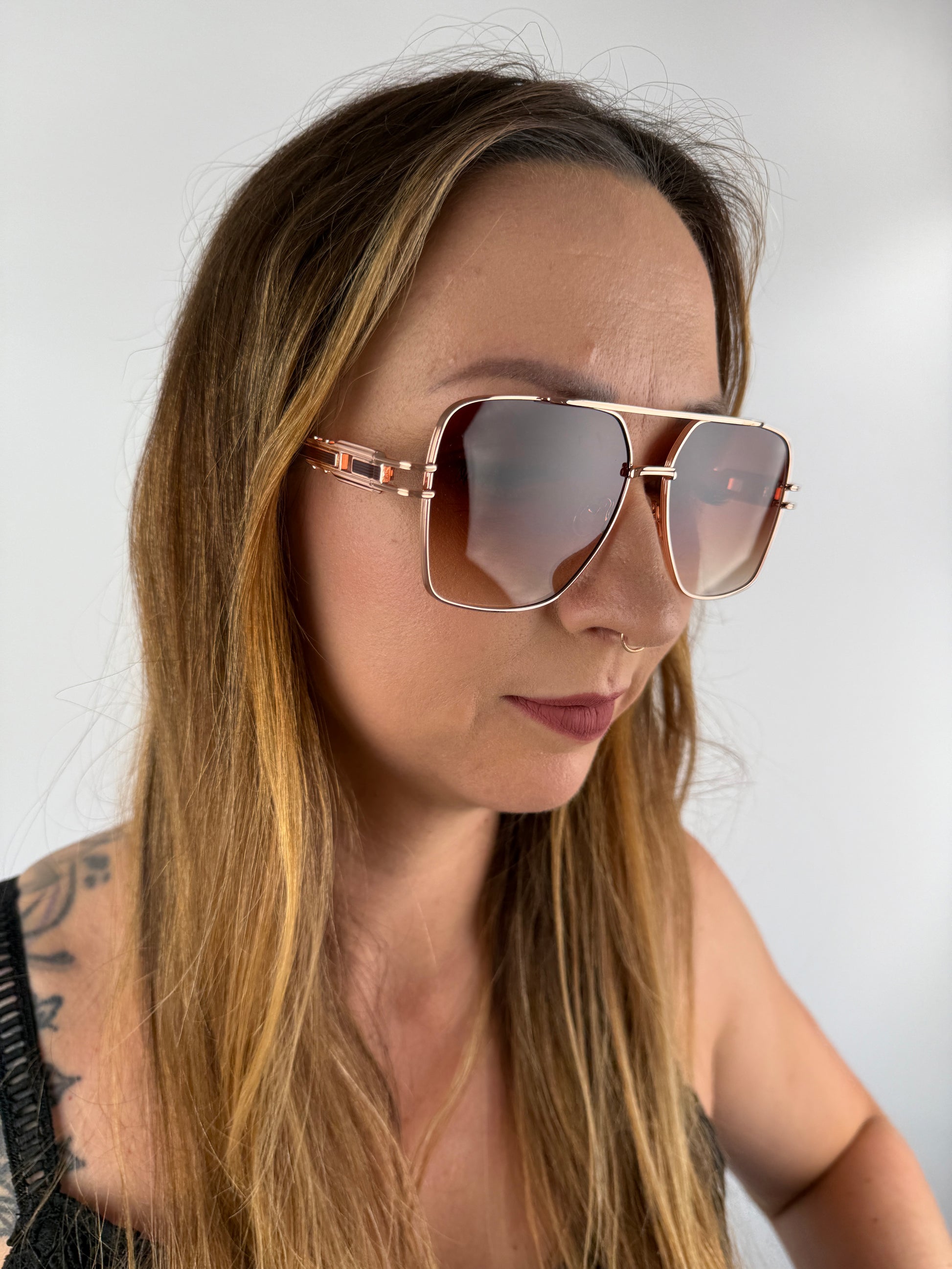 Sonnenbrille mit Braunen nach unten heller werdenden Gläsern und rose Goldenem Gestell.