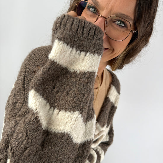 Detailaufnahme der flauschigen Strickjacke in Braun und Creme – weiche Struktur und gemütliche Passform.