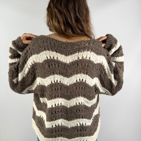 Rückenansicht einer braun-cremefarbenen Strickjacke mit wellenförmigem Streifenmuster – locker geschnitten und weich fallend.
