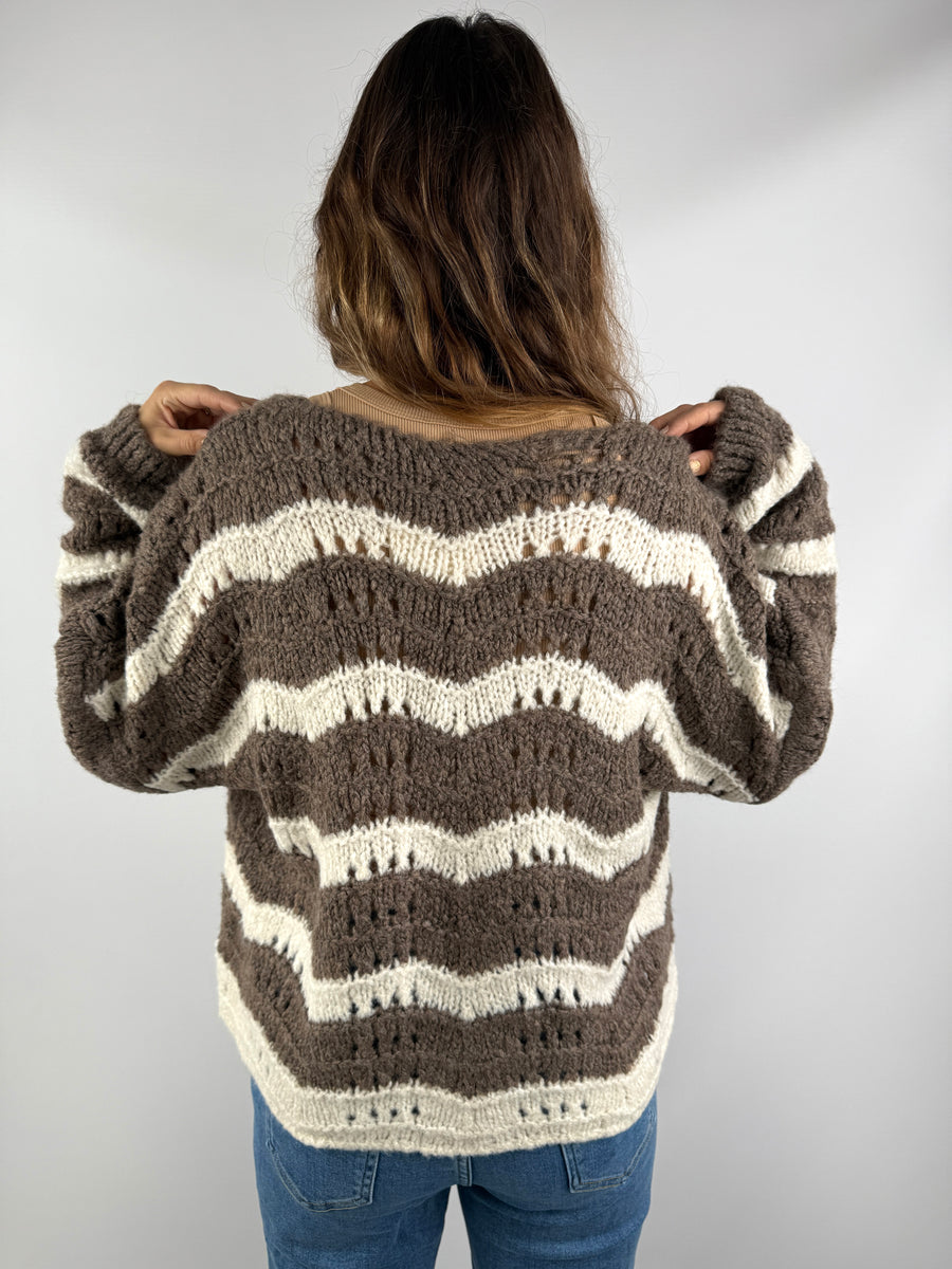 Rückenansicht einer braun-cremefarbenen Strickjacke mit wellenförmigem Streifenmuster – locker geschnitten und weich fallend.
