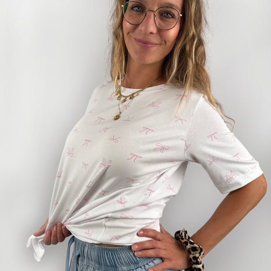 weißes T-Shirt mit kleinen feinen rosa Schleifen.