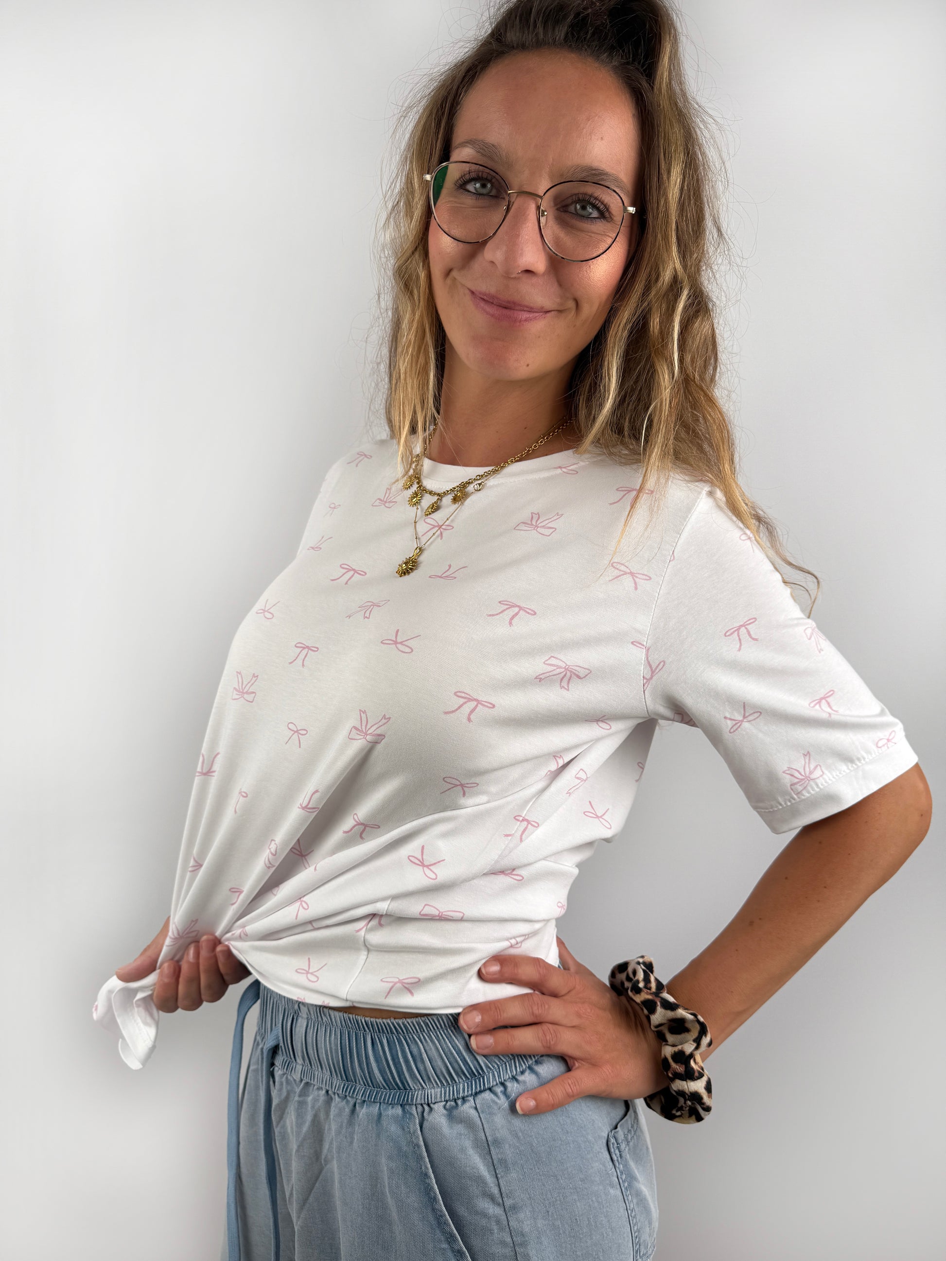 weißes T-Shirt mit kleinen feinen rosa Schleifen.