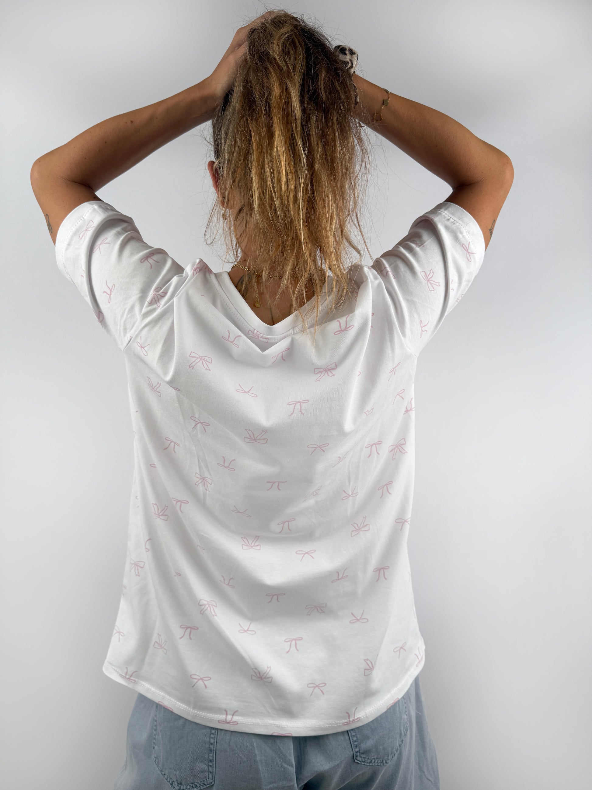 weißes T-Shirt mit kleinen feinen rosa Schleifen.