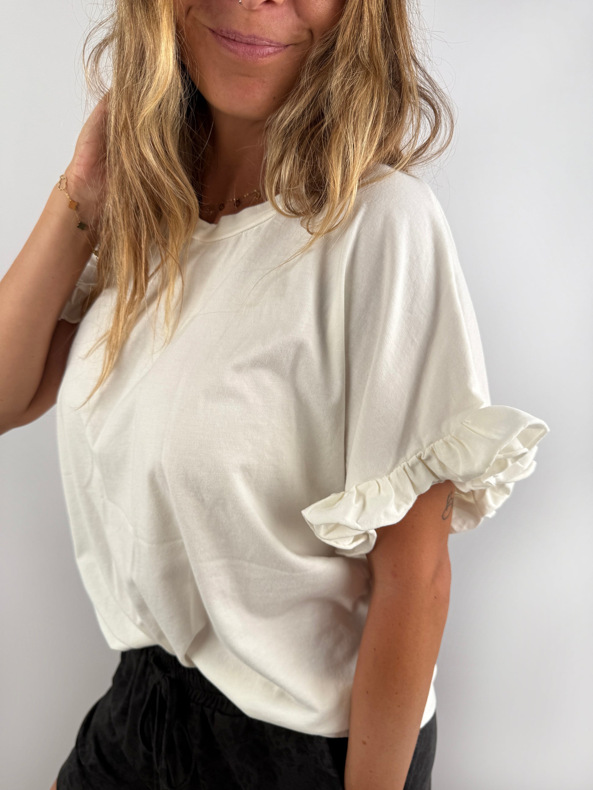 Creme farbenes T-Shirt mit Rüschen Ärmel.