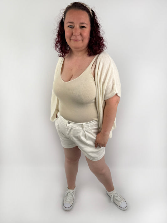 Wollweste in seichten farben mit kurzen Ärmeln und hellen größeren Knöpfen an der Vorderseite.