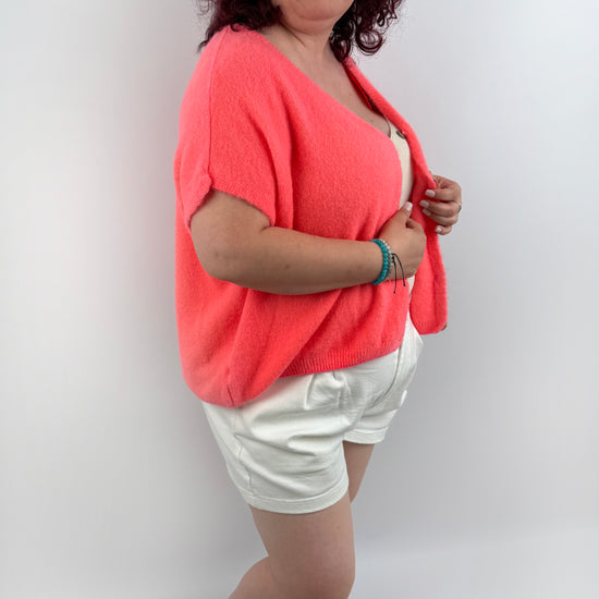 Wollweste in seichten farben mit kurzen Ärmeln und hellen größeren Knöpfen an der Vorderseite.