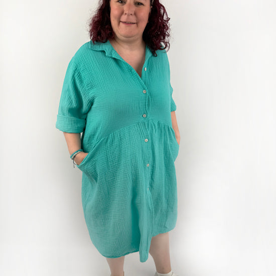XL Musselin Kleid mit Knopfreiehe und seitlichen Taschen und 3/4 Ärmeln in der Farbe Türkis.