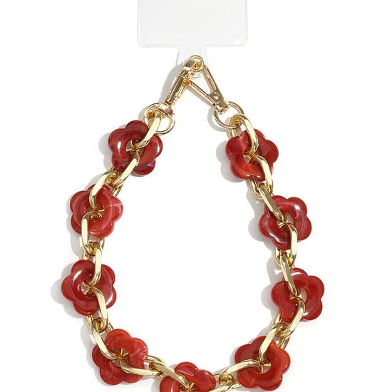 Handykette mit goldener Gliederkette und roten Acryl-Blumen auf weißem Hintergrund