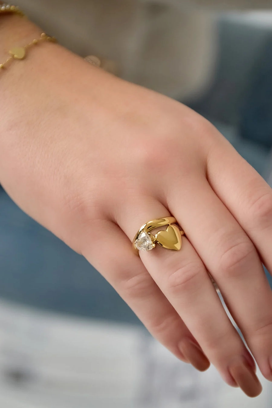 Goldener, verstellbarer Ring mit Herz und Kristall an einer Hand getragen 
